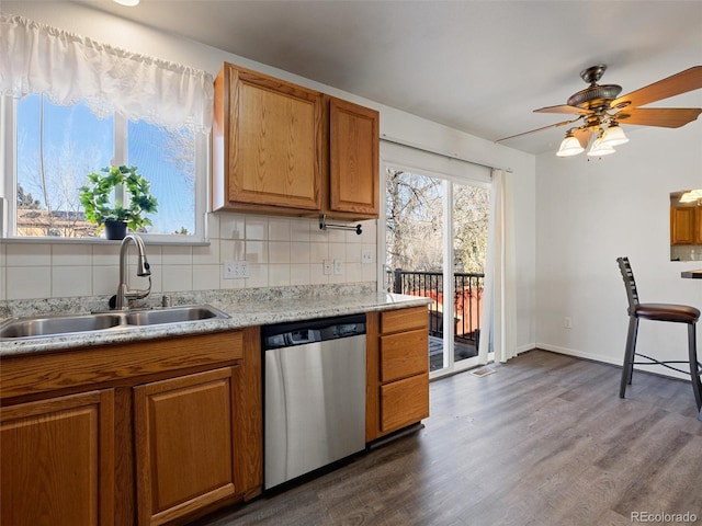 kitchen with sink, ceiling fan, stainless steel dishwasher, backsplash, and dark hardwood / wood-style flooring