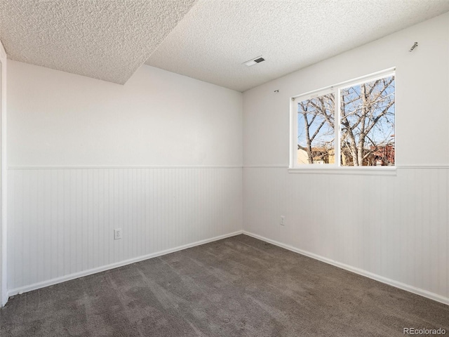 carpeted spare room featuring a textured ceiling