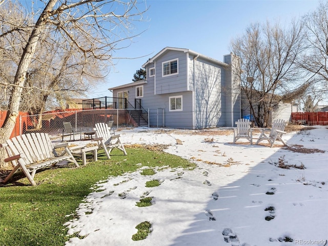 view of snow covered rear of property