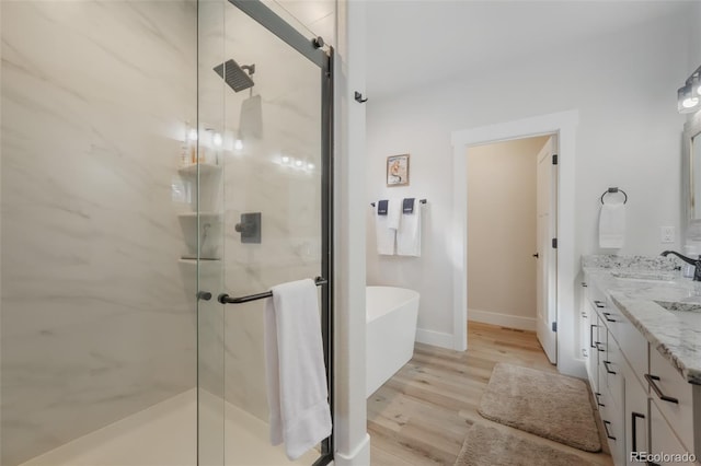 bathroom featuring independent shower and bath, vanity, and hardwood / wood-style flooring