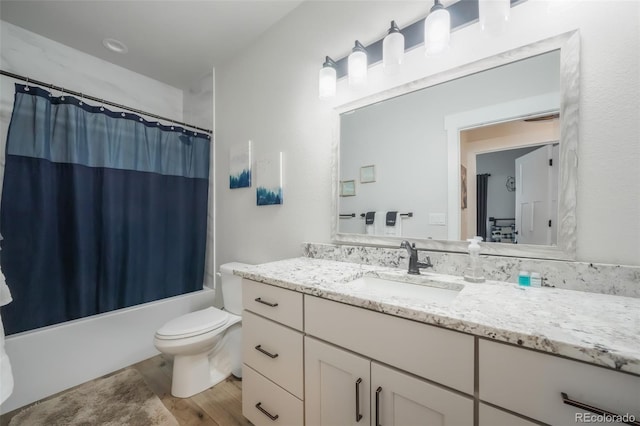 full bathroom featuring vanity, hardwood / wood-style floors, shower / bathtub combination with curtain, and toilet