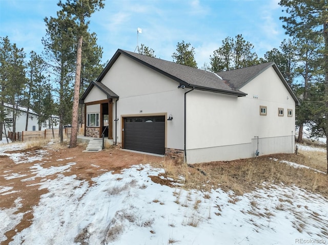 view of snowy exterior with a garage