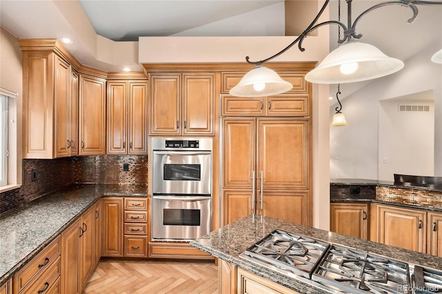 3231 Oak St, Wheat Ridge, CO 80033 - kitchen with stainless steel appliances, tasteful backsplash, dark stone counters, hanging light fixtures, and brown cabinetry