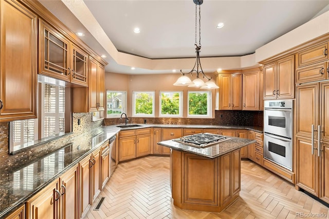 3231 Oak St, Wheat Ridge, CO 80033 - kitchen with appliances with stainless steel finishes, a center island, dark stone counters, decorative backsplash, and recessed lighting