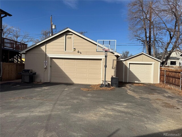 detached garage featuring fence and central AC