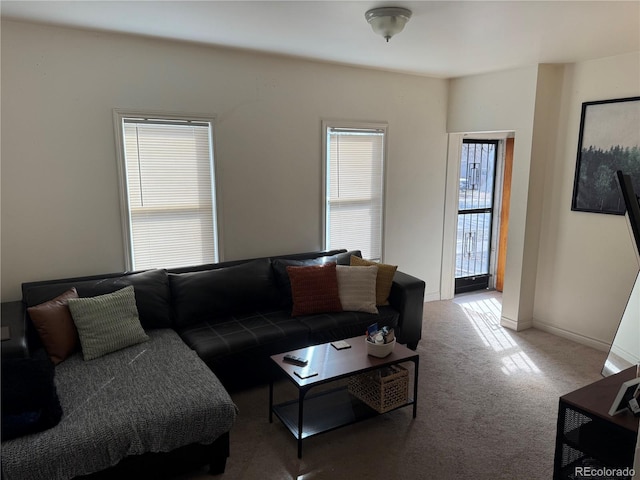 living room featuring carpet and baseboards