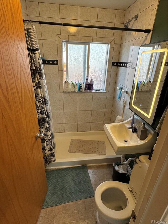 bathroom featuring a shower stall, toilet, and a sink