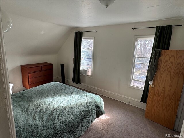 carpeted bedroom with multiple windows, baseboards, and vaulted ceiling