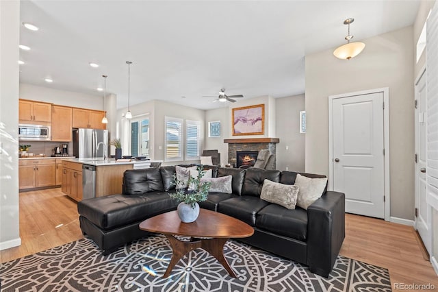 48 Mayflower Park Pl, Colorado Springs, CO 80905 - living area with light wood-type flooring, a ceiling fan, a stone fireplace, and recessed lighting