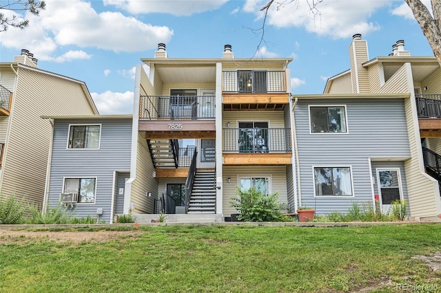 7825 Barbara Ann Dr Unit I, Arvada, CO 80004 - rear view of house featuring stairway, a balcony, and a lawn