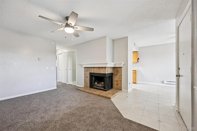 7825 Barbara Ann Dr Unit I, Arvada, CO 80004 - unfurnished living room featuring ceiling fan, a tiled fireplace, a baseboard radiator, a textured ceiling, and light tile patterned floors