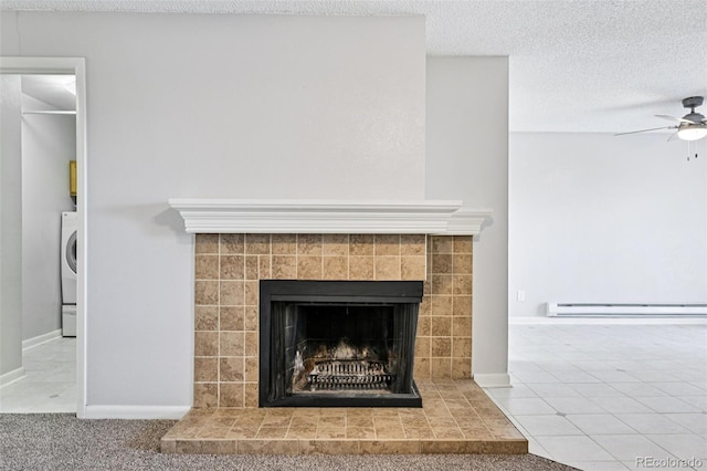 7825 Barbara Ann Dr Unit I, Arvada, CO 80004 - detailed view of a baseboard radiator, a tile fireplace, a ceiling fan, a textured ceiling, and washer / dryer