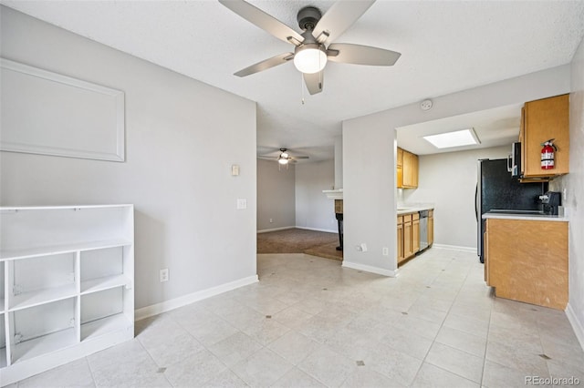 7825 Barbara Ann Dr Unit I, Arvada, CO 80004 - kitchen with a ceiling fan, stainless steel dishwasher, brown cabinets, light countertops, and open floor plan