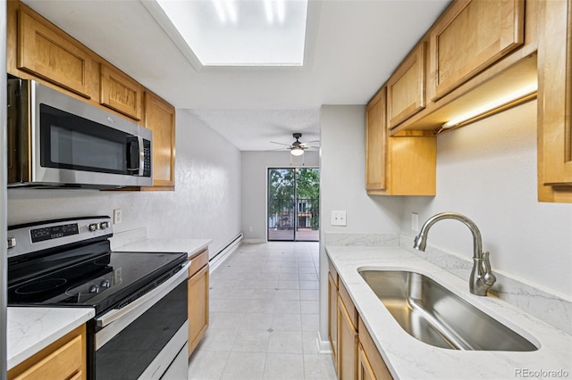 7825 Barbara Ann Dr Unit I, Arvada, CO 80004 - kitchen featuring appliances with stainless steel finishes, light tile patterned flooring, a ceiling fan, light stone countertops, and baseboard heating