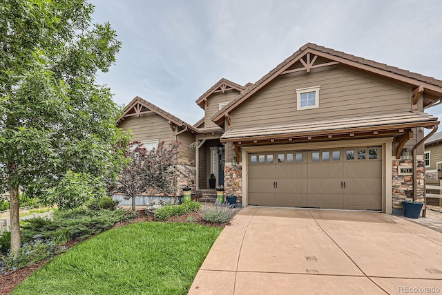 craftsman-style house featuring a garage and a front lawn