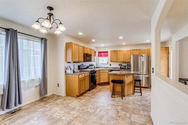 5770 Waverley Ave, Firestone, CO 80504 - kitchen with freestanding refrigerator, black gas stove, a breakfast bar area, a chandelier, and a kitchen island