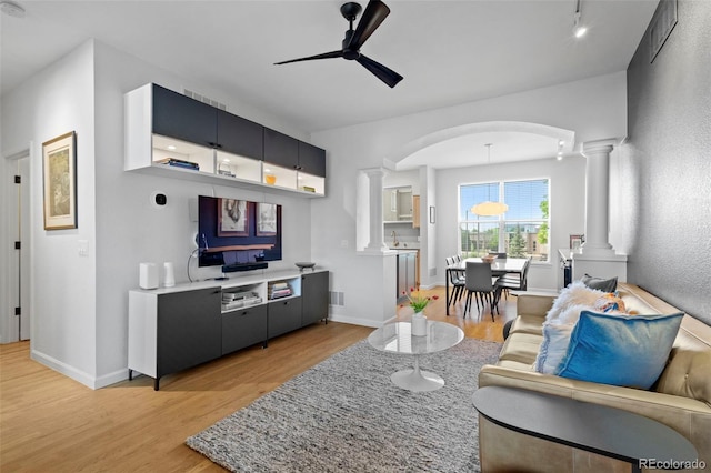 84 Spruce St Unit 707, Denver, CO 80230 - living area featuring ornate columns, light wood-style floors, ceiling fan, arched walkways, and baseboards