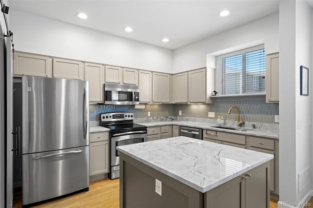 84 Spruce St Unit 707, Denver, CO 80230 - kitchen with appliances with stainless steel finishes, a sink, gray cabinets, a kitchen island, and decorative backsplash