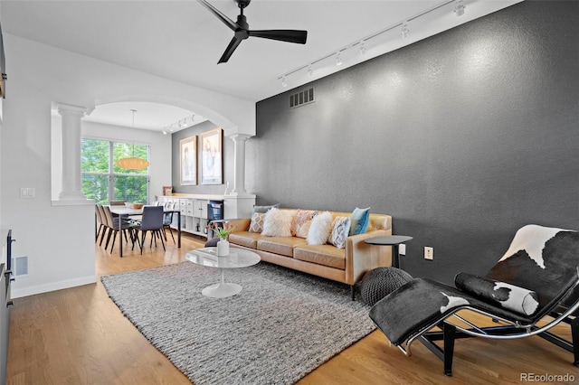 84 Spruce St Unit 707, Denver, CO 80230 - living room with rail lighting, decorative columns, arched walkways, and wood finished floors