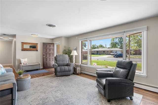 sitting room with light wood-type flooring and baseboard heating