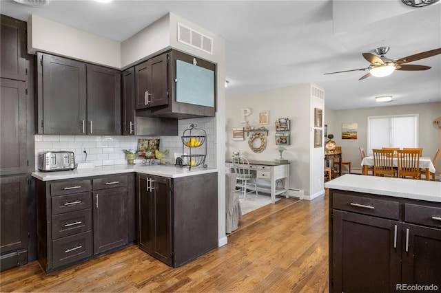 kitchen with ceiling fan, dark brown cabinets, light hardwood / wood-style floors, and decorative backsplash