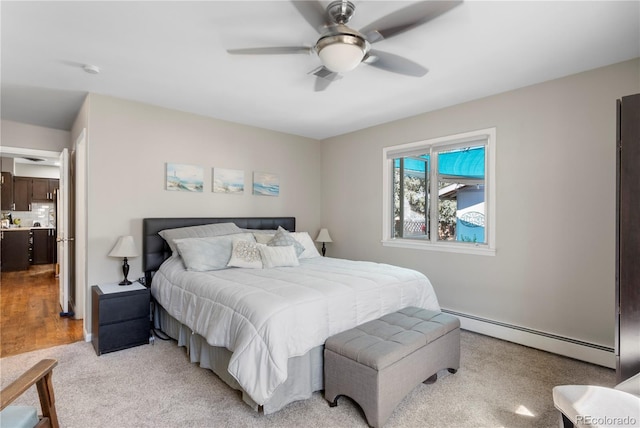 carpeted bedroom with ceiling fan and baseboard heating