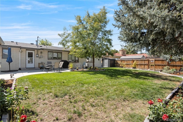 view of yard with a storage shed and a patio area