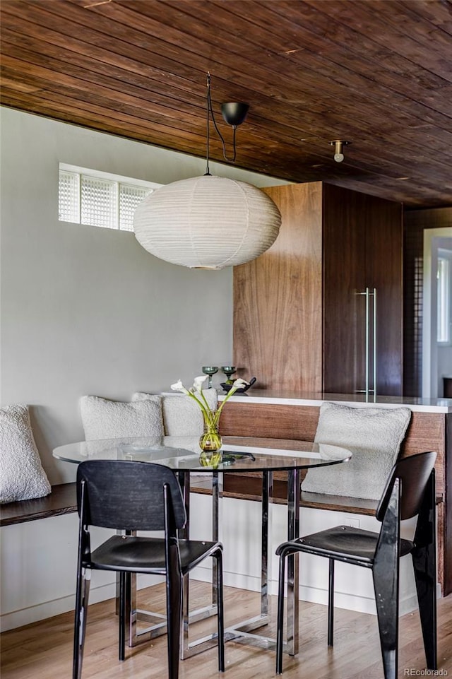 dining room featuring breakfast area, wooden ceiling, and light wood-style flooring