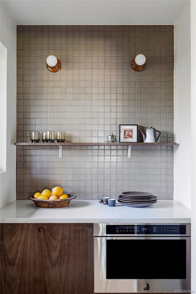 kitchen featuring light countertops, oven, and decorative backsplash