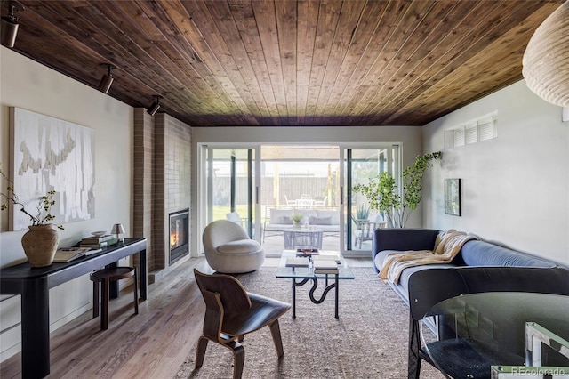 living area with wooden ceiling, a fireplace, and wood finished floors