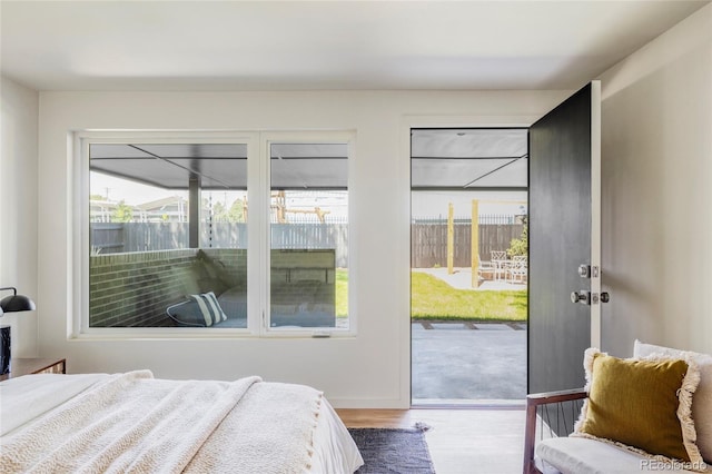 bedroom with access to exterior, baseboards, and wood finished floors