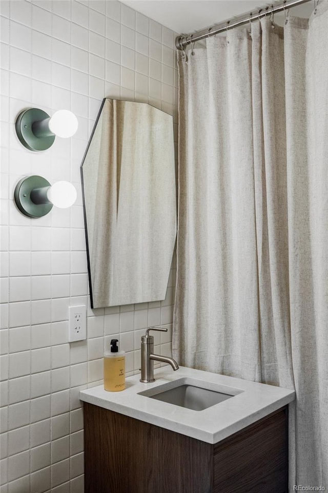 bathroom featuring tasteful backsplash, tile walls, and vanity