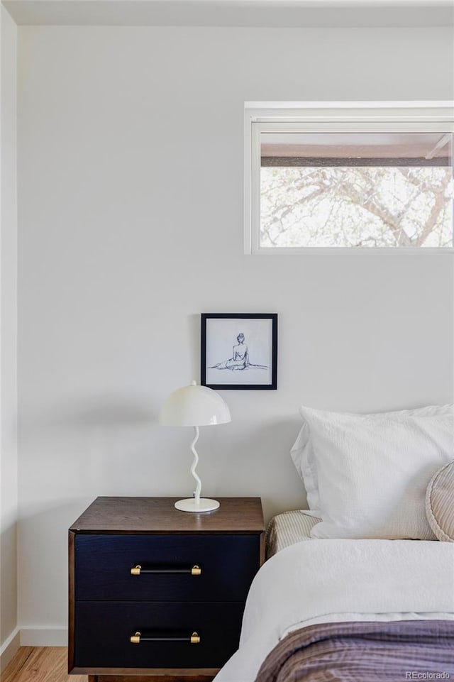 bedroom with baseboards and wood finished floors