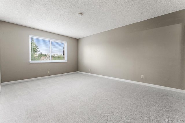 empty room with light carpet and a textured ceiling