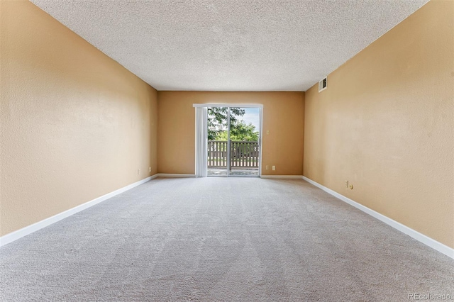 empty room featuring carpet and a textured ceiling