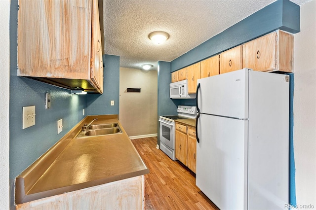 kitchen with a textured ceiling, white appliances, light hardwood / wood-style flooring, and sink