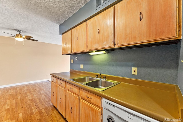 kitchen with light wood-type flooring, a textured ceiling, white dishwasher, ceiling fan, and sink