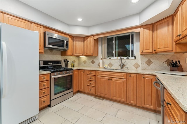 12906 Cherry Way, Thornton, CO 80241 - kitchen with appliances with stainless steel finishes, light stone countertops, decorative backsplash, light tile patterned floors, and recessed lighting