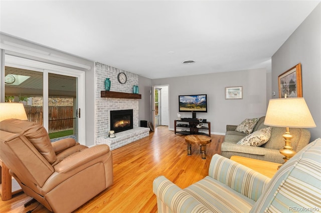 12906 Cherry Way, Thornton, CO 80241 - living area featuring light wood finished floors and a brick fireplace