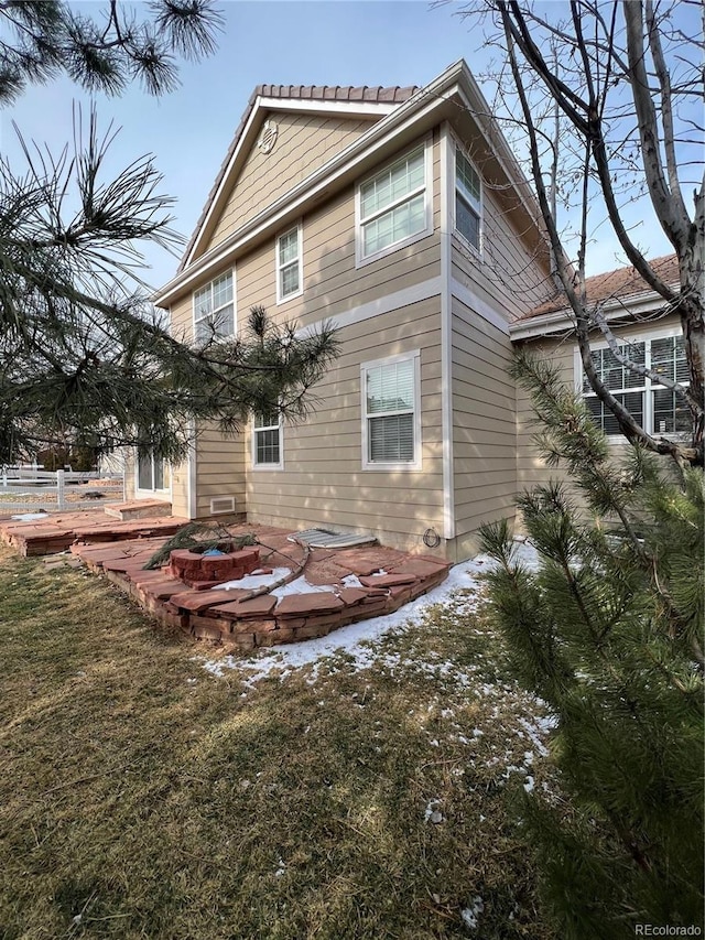 back of property with a patio, a lawn, and an outdoor fire pit