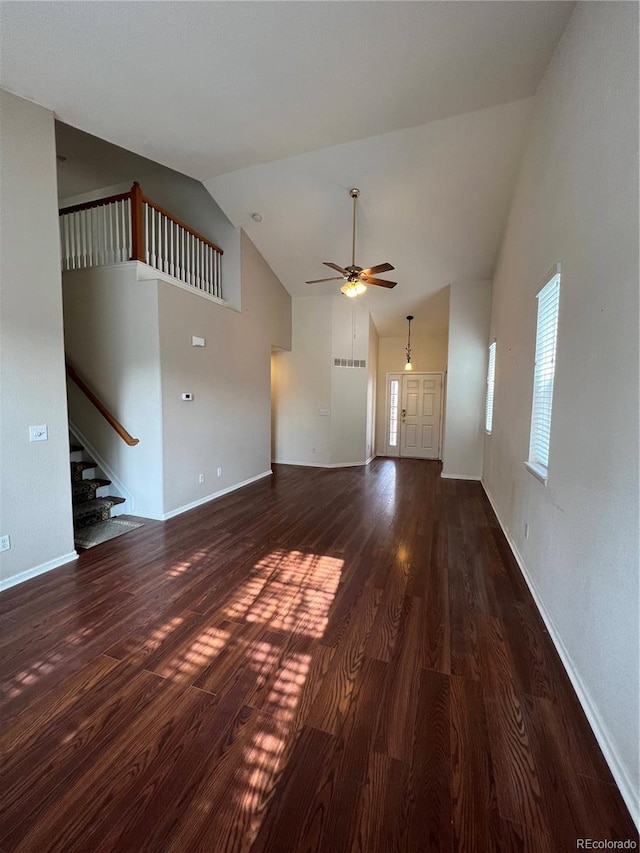 unfurnished living room featuring ceiling fan, stairway, wood finished floors, and high vaulted ceiling