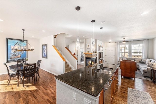 3751 W 136th Ave Unit S3, Broomfield, CO 80023 - kitchen with a sink, a fireplace, open floor plan, dishwasher, and dark wood finished floors