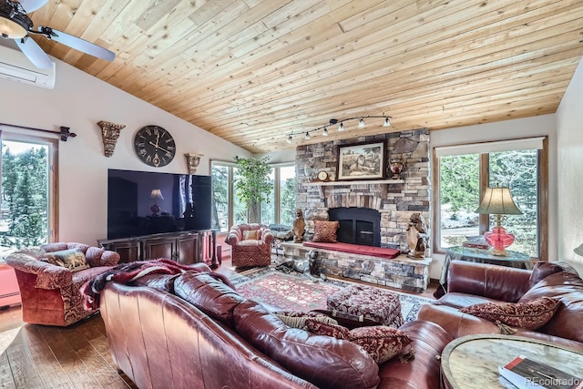 living room featuring vaulted ceiling, wood-type flooring, a fireplace, and plenty of natural light