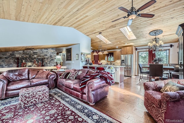 living area with ceiling fan with notable chandelier, a skylight, wood finished floors, and wooden ceiling