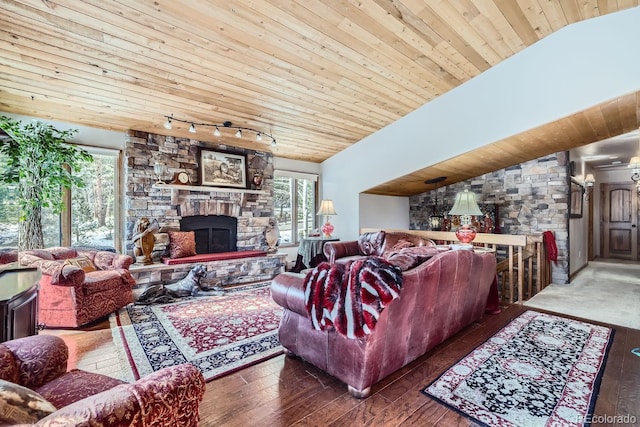 living room with vaulted ceiling, a stone fireplace, hardwood / wood-style flooring, and wood ceiling