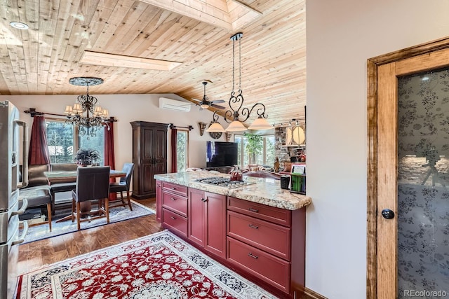 kitchen with lofted ceiling with skylight, wood ceiling, dark wood-style floors, decorative light fixtures, and an AC wall unit