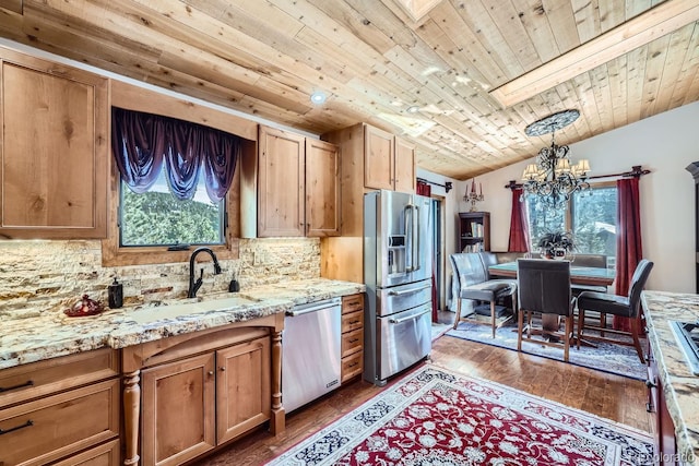 kitchen with appliances with stainless steel finishes, dark wood-type flooring, a sink, vaulted ceiling, and backsplash