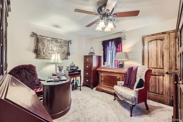 sitting room with ceiling fan and light colored carpet