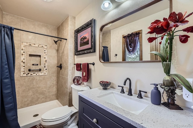 bathroom with toilet, a shower stall, and vanity