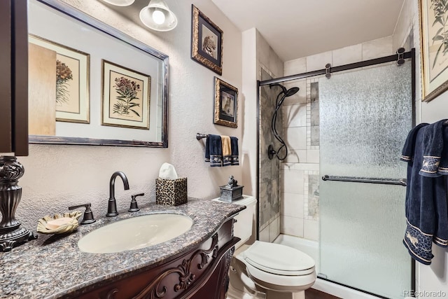 full bathroom featuring a stall shower, vanity, and toilet